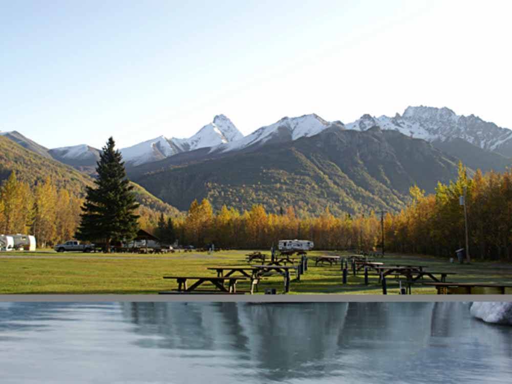 A row of picnic benches with snow capped mountains in the background at MOUNTAIN VIEW RV PARK