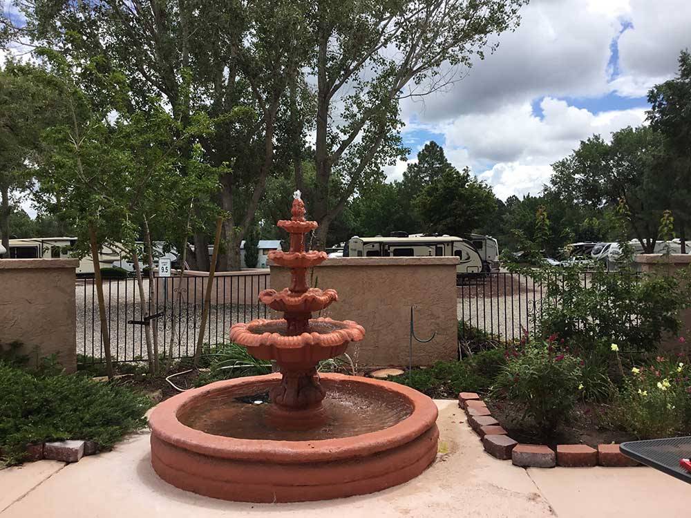Water fountain with RVs in distance at J & H RV PARK