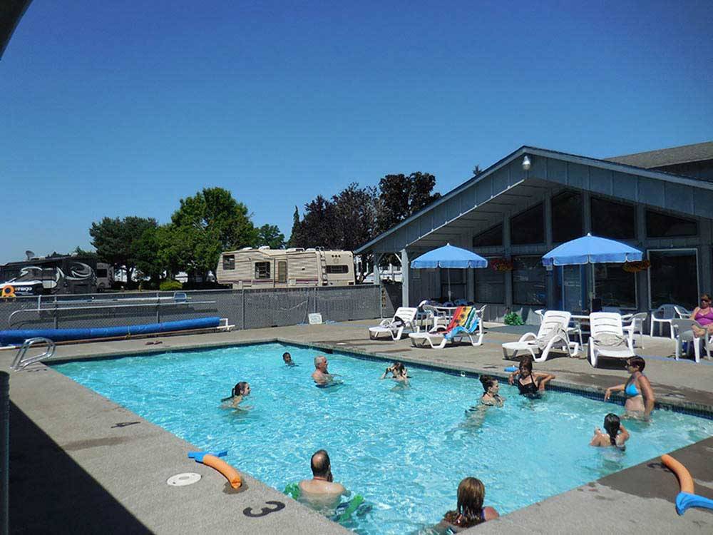 People swimming in the pool at PORTLAND WOODBURN RV PARK