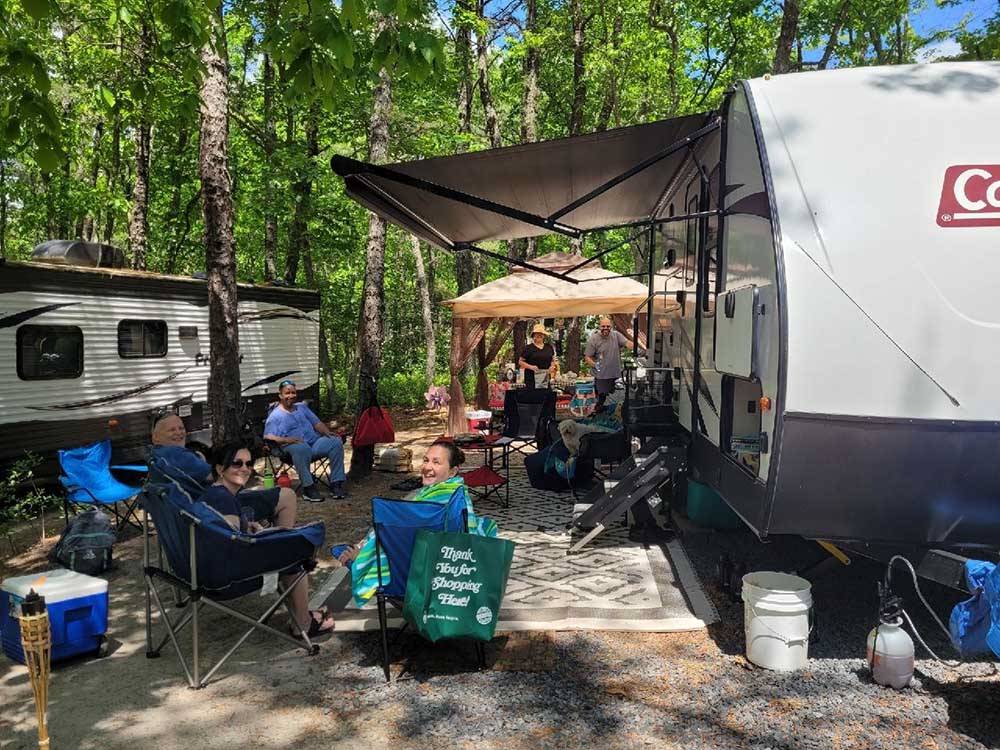 People sitting outside of an RV at INDIAN ROCK RV PARK