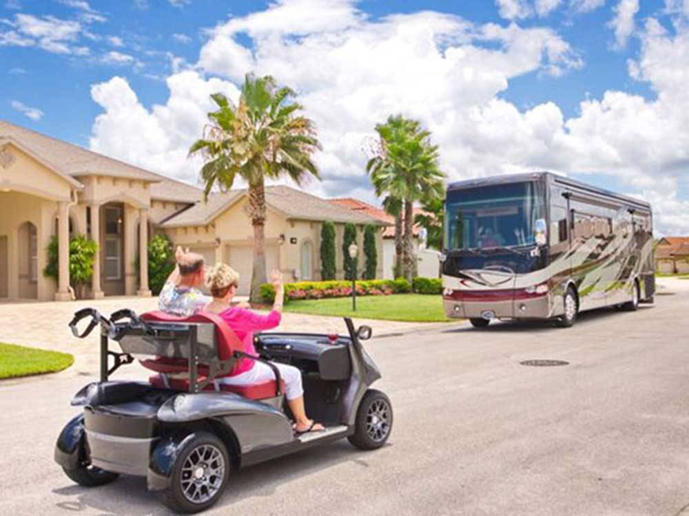 A golf cart driving down the road at THE GREAT OUTDOORS RV NATURE & GOLF RESORT