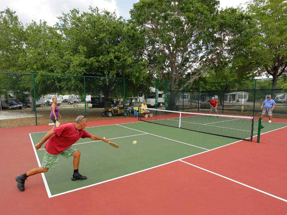 Campers playing tennis at ENCORE HARBOR LAKES
