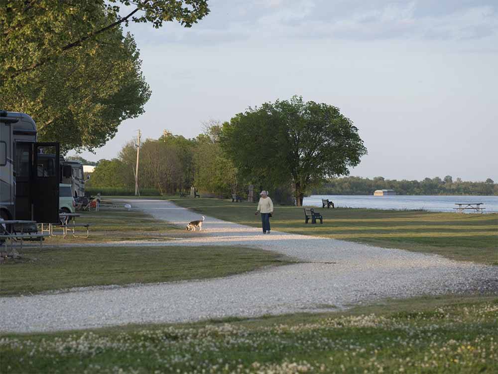 A woman walking her dog at TOM SAWYER'S RV PARK