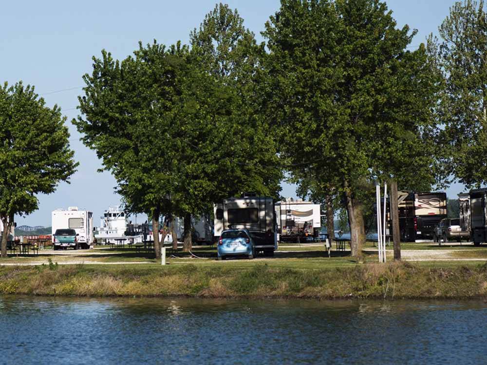 RVs with trees by the water at TOM SAWYER'S RV PARK