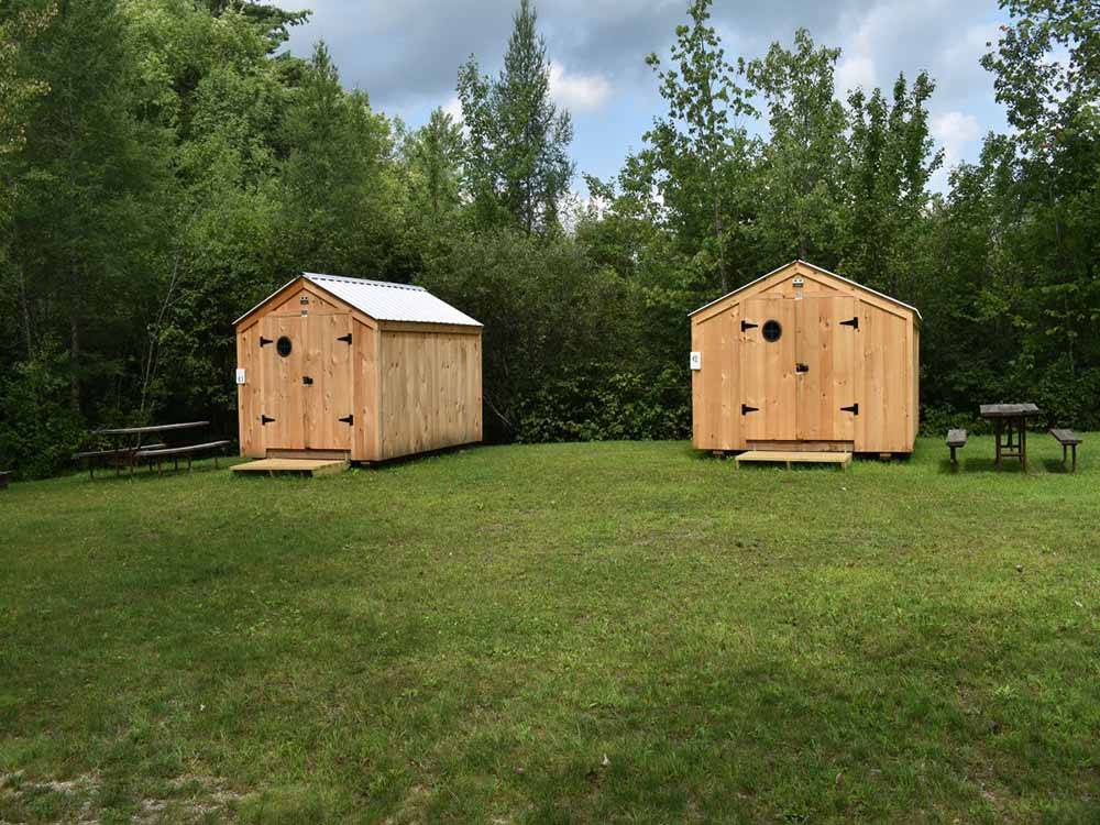 Two log cabins with picnic benches at DORSET RV PARK