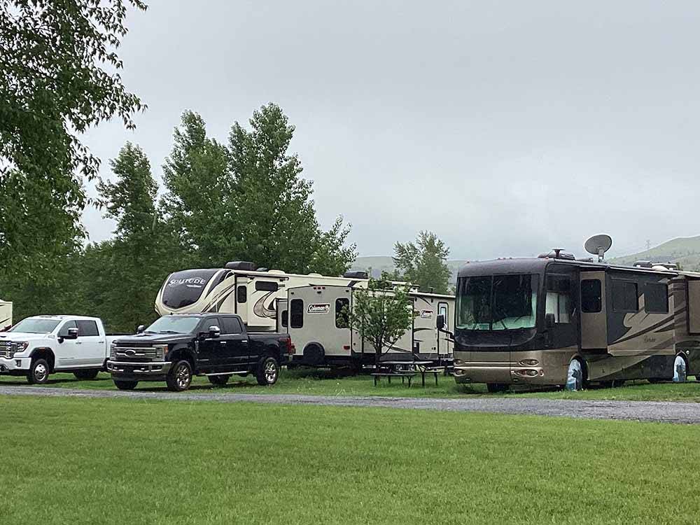 A couple of RVs in grassy sites at RIVERFRONT RV PARK