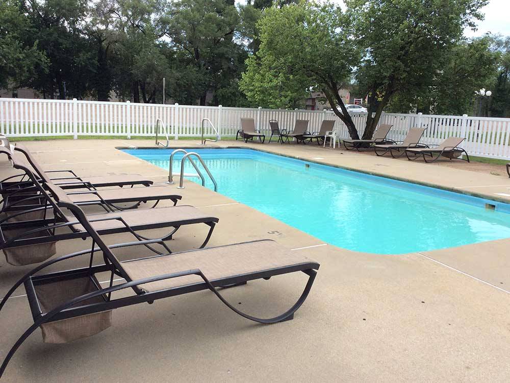 Community swimming pool with lounge chairs around it at CAHOKIA RV PARQUE