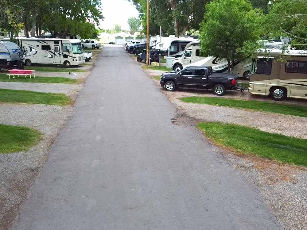 The paved road in between gravel RV sites at FOSSIL VALLEY RV PARK