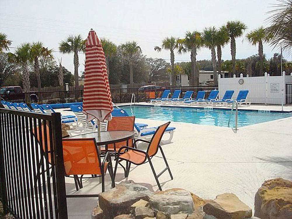 Swimming pool with outdoor seating at OCALA SUN RV RESORT