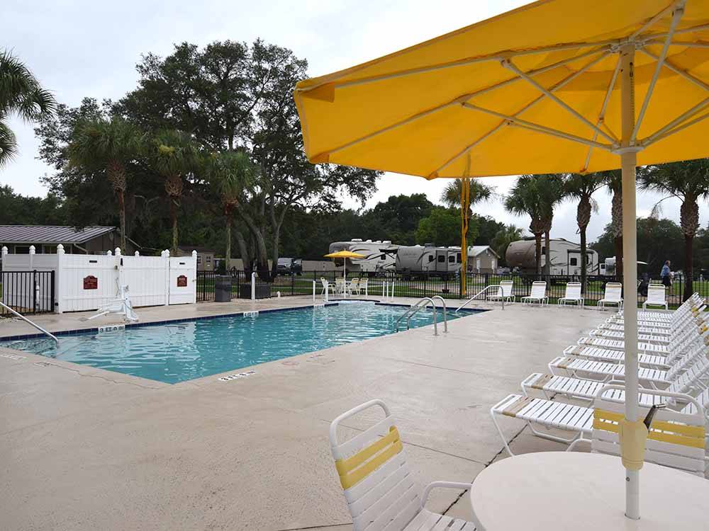 Lounge chairs by the swimming pool at OCALA SUN RV RESORT