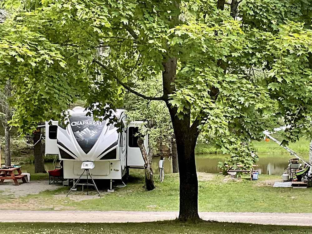 A fifth wheel trailer in an RV site by the water at PAUL BUNYAN CAMPGROUND