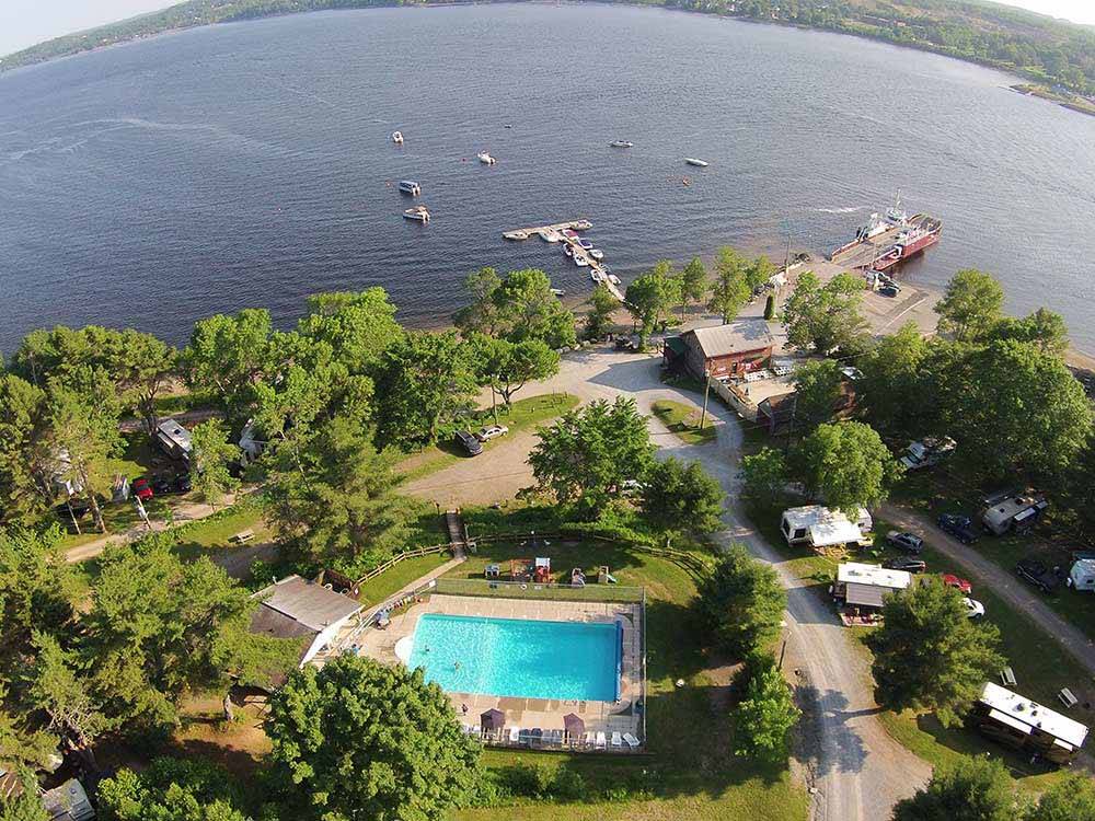 Aerial view of beautiful pool, woods, and lake with boats at HARDINGS POINT CAMPGROUND