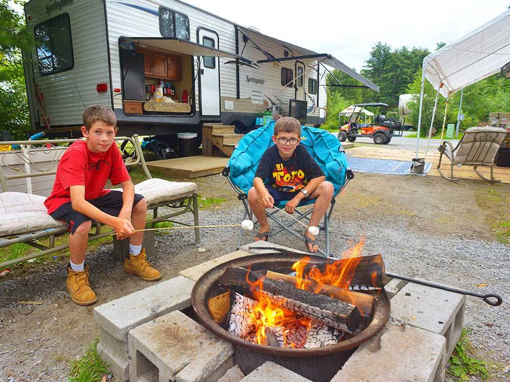 Kids roasting marshmallows at LAKE GEORGE ESCAPE CAMPGROUND