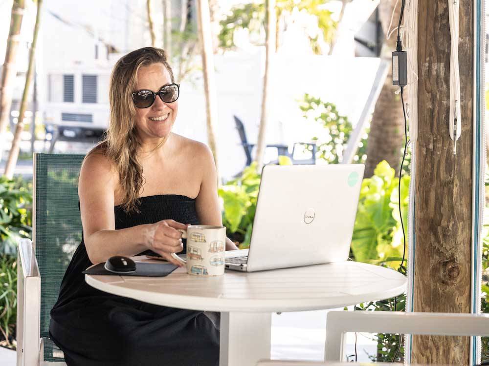 A lady sitting at a table on her computer at SUN OUTDOORS SUGARLOAF KEY