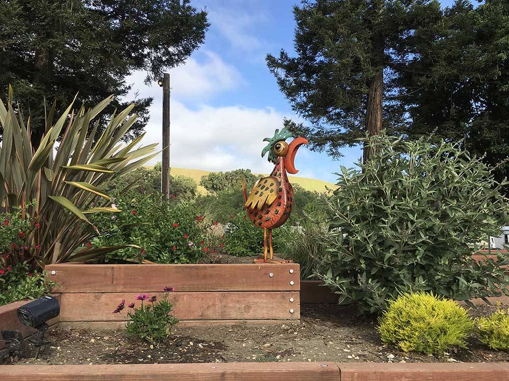 Statue of a rooster in a garden at BETABEL RV PARK