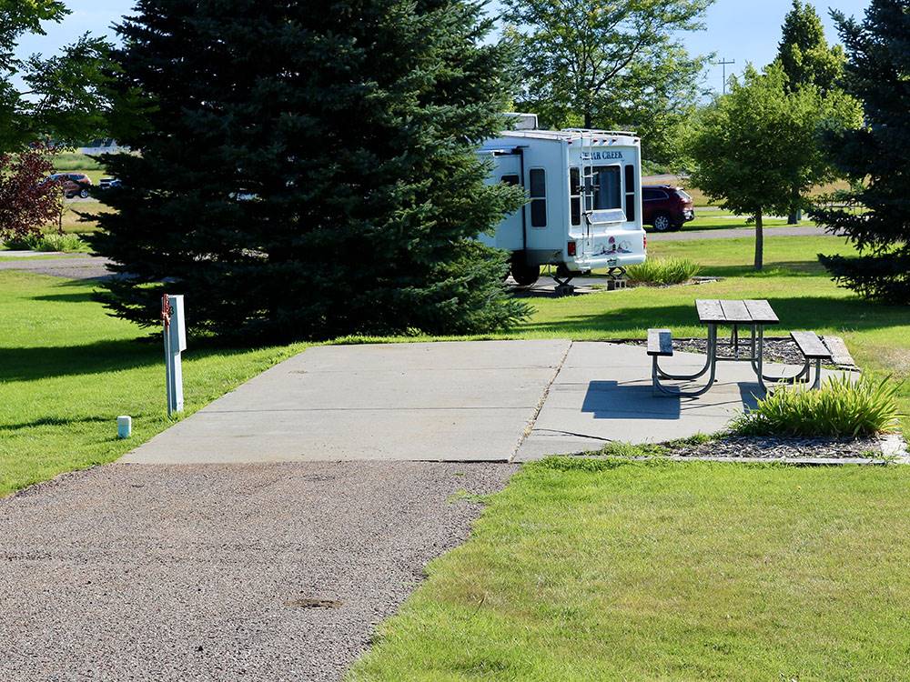 An empty paved RV site with a picnic table at ROBIDOUX RV PARK