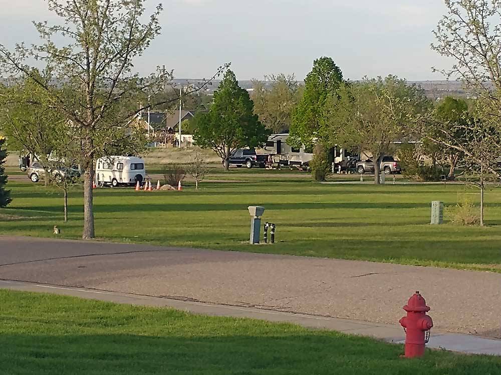 Red fire hydrant with RVs and green spaces in background at ROBIDOUX RV PARK