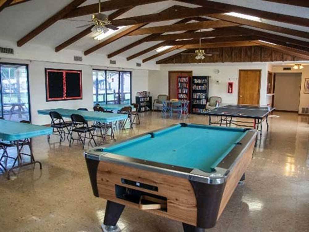 Pool table under vaunted ceiling with coke machine in background at TOWN & COUNTRY RV PARK