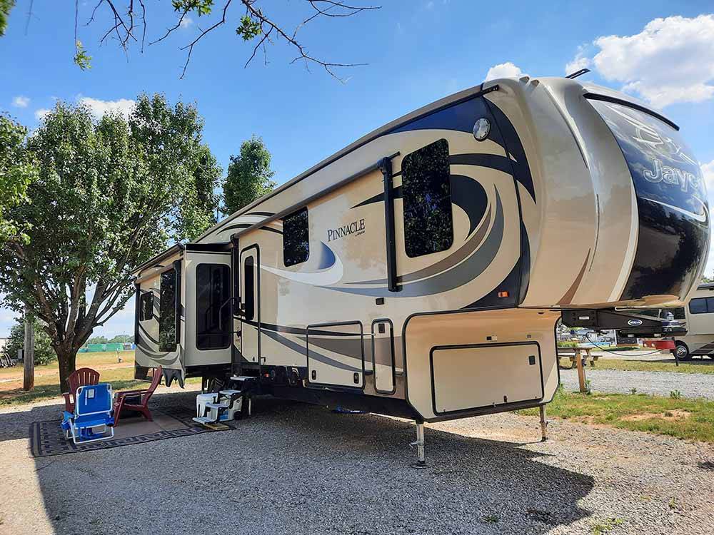 A gravel RV site with a fifth wheel trailer at DAD'S BLUEGRASS CAMPGROUND