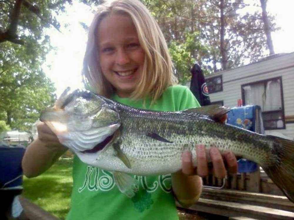 A girl holding a fish at LEHMAN'S LAKESIDE RV RESORT