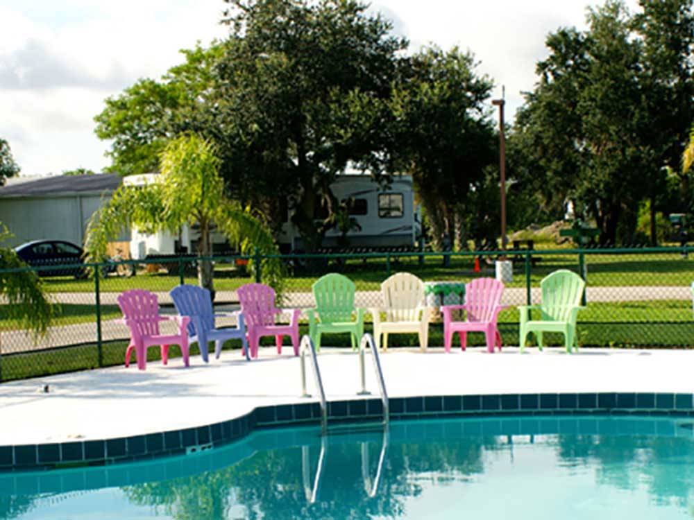 Swimming pool with colorful chairs at SONRISE PALMS RV PARK