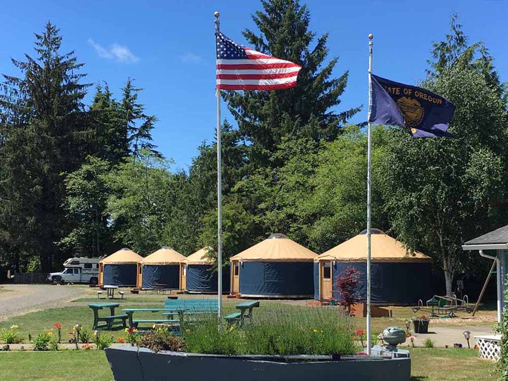 A sailboat with flags in front of five yurts at TILLAMOOK BAY CITY RV PARK