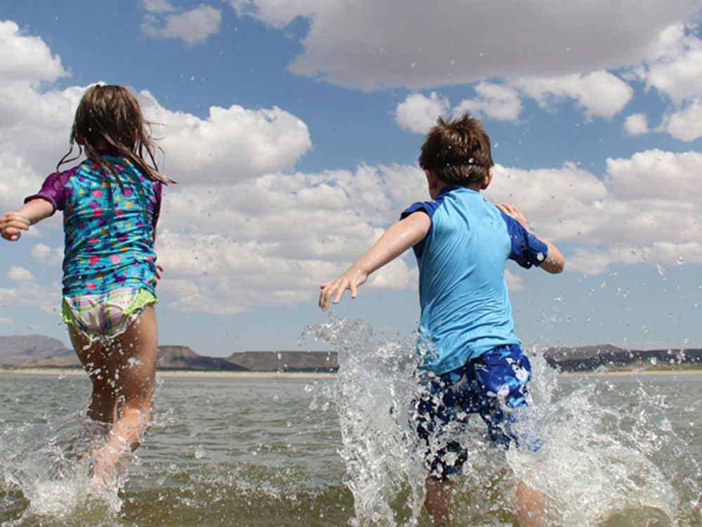 Kids running into the beach at ELEPHANT BUTTE LAKE RV RESORT