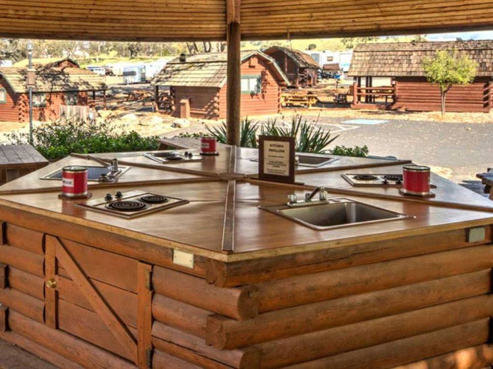 Outdoor bar with cabins in the background at ANGELS CAMP RV RESORT