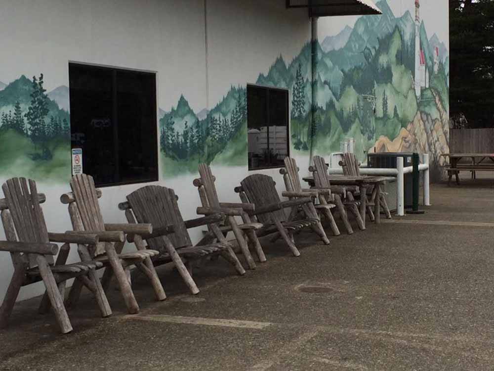Rustic chairs outside of the registration building at PACIFIC PINES RV PARK & STORAGE