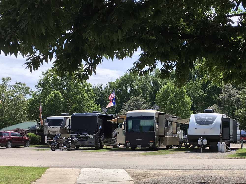 RVs parked in a few of the sites at OUTDOOR LIVING CENTER RV PARK