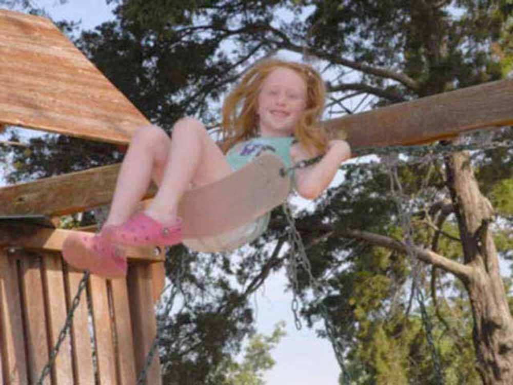 A child swinging on a swing at AMERICA'S BEST CAMPGROUND