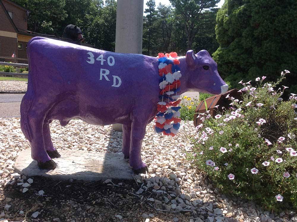 A cow statue next to some flowers at WAYNESBORO NORTH 340 CAMPGROUND