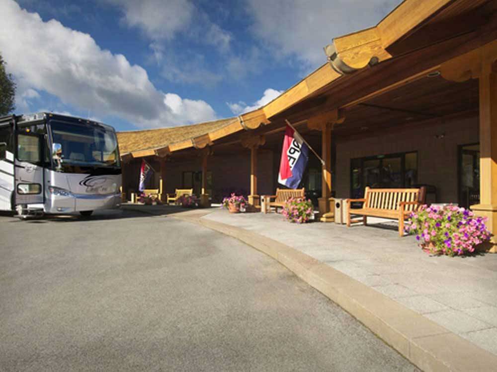 Office with flag and benches in front at THE VILLAGES AT TURNING STONE RV PARK