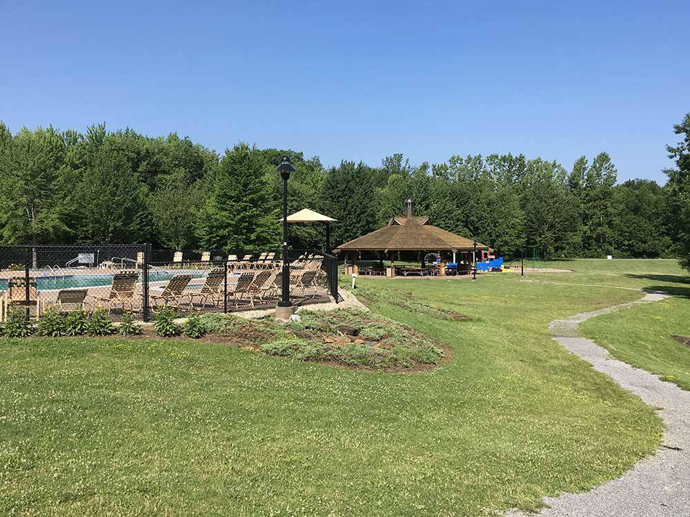 Community swimming pool beside outdoor gazebo at THE VILLAGES AT TURNING STONE RV PARK