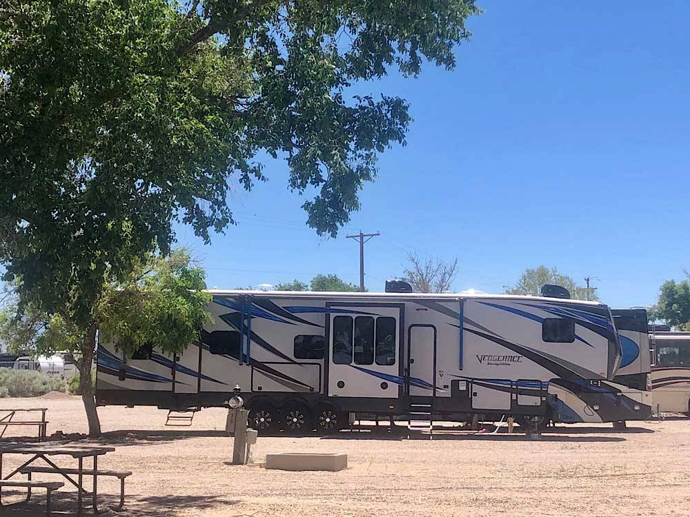 Large trailer parked on gravel site at ENCHANTED TRAILS RV PARK & TRADING POST