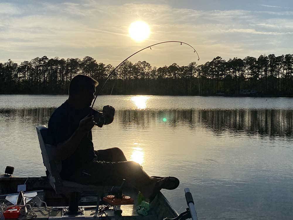 A man fishing at sunset at LAKE HARMONY RV PARK AND CAMPGROUND