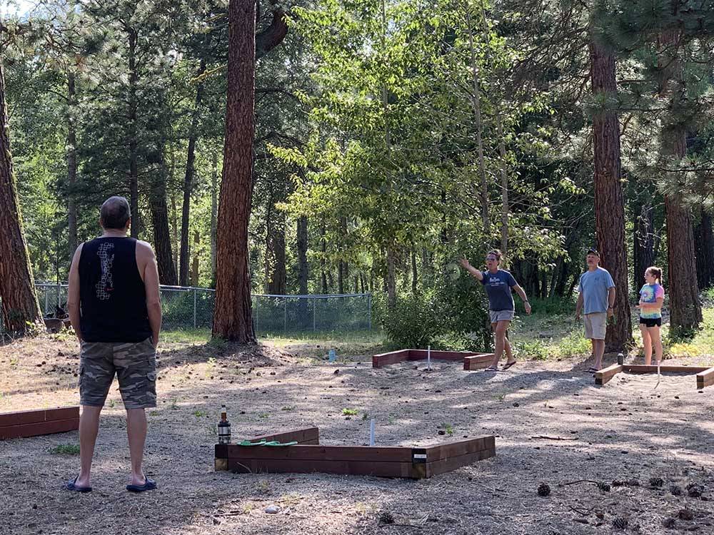 A family playing horseshoes at WHISPERING PINES RV CAMPGROUND