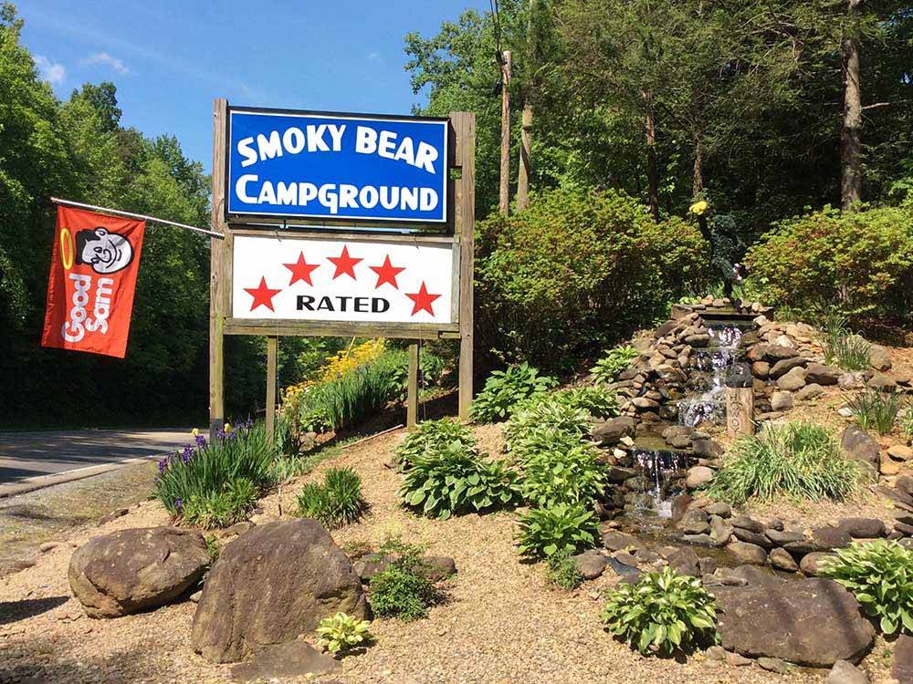 Park sign at entrance with small waterfall feature at SMOKY BEAR CAMPGROUND AND RV PARK