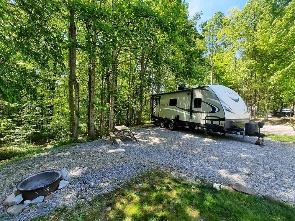 A travel trailer parked in a gravel site at SMOKY BEAR CAMPGROUND AND RV PARK