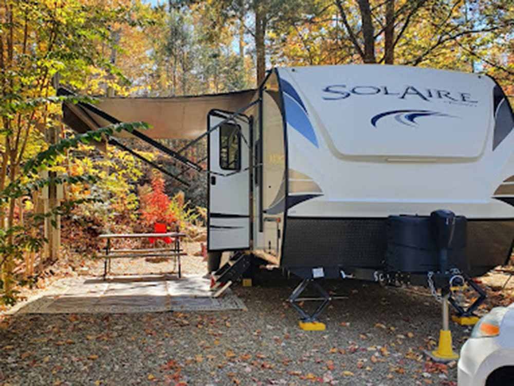 A Solaire trailer parked in a RV site next to a picnic bench at SMOKY BEAR CAMPGROUND AND RV PARK