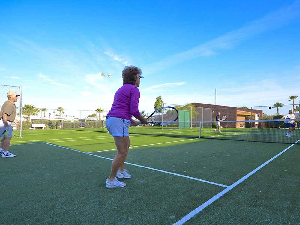 Couples playing tennis at APACHE WELLS RV RESORT