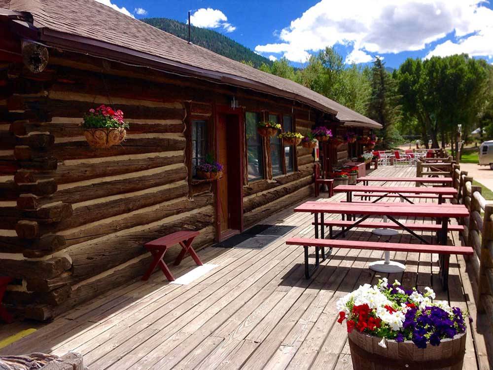Lodging with deck and picnic tables at ELK MEADOW LODGE AND RV RESORT