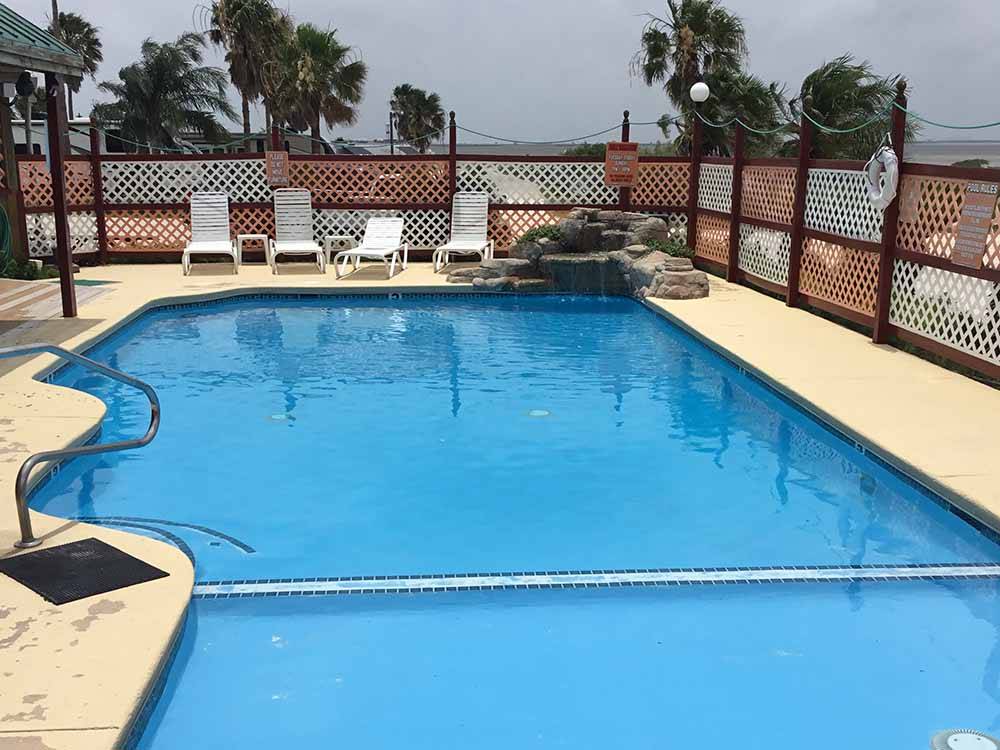 A very blue pool with lounge chairs at SEA BREEZE RV COMMUNITY RESORT