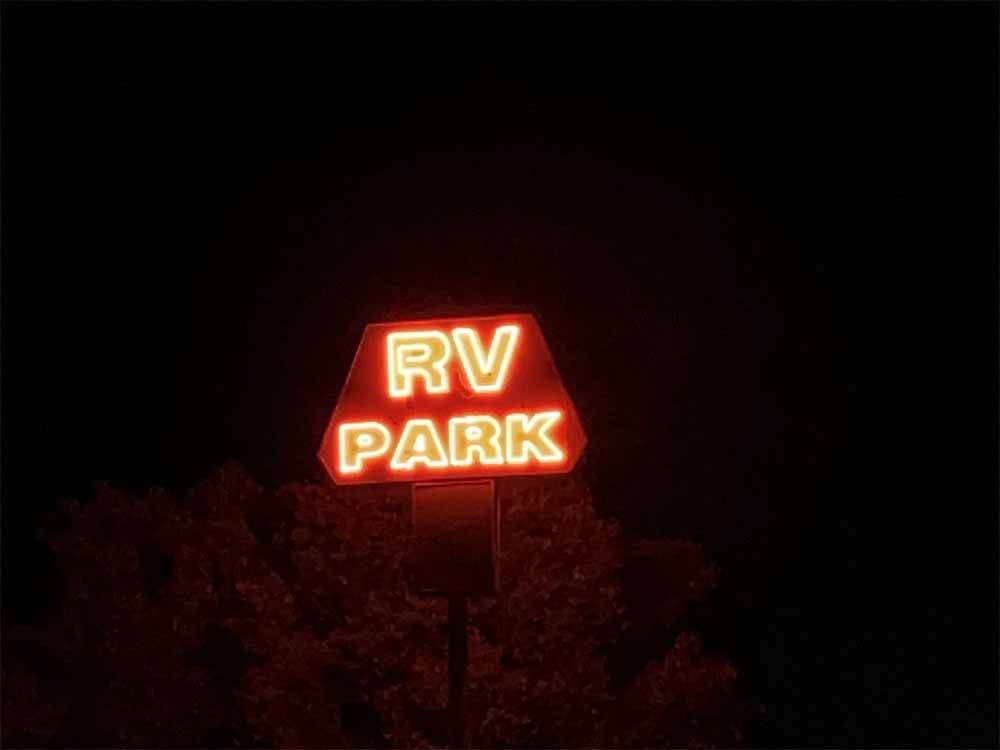 The lit up red neon main entrance sign at ELKO RV PARK