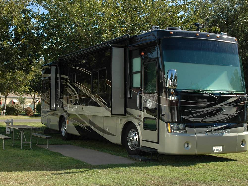 A Class A motorhome parked in a grassy site at SUGAR BARGE RV RESORT AND MARINA