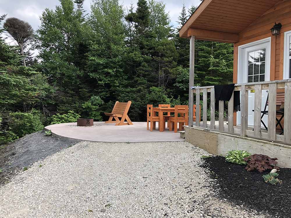 A seating area next to a rental cabin at GROS MORNE/NORRIS POINT KOA
