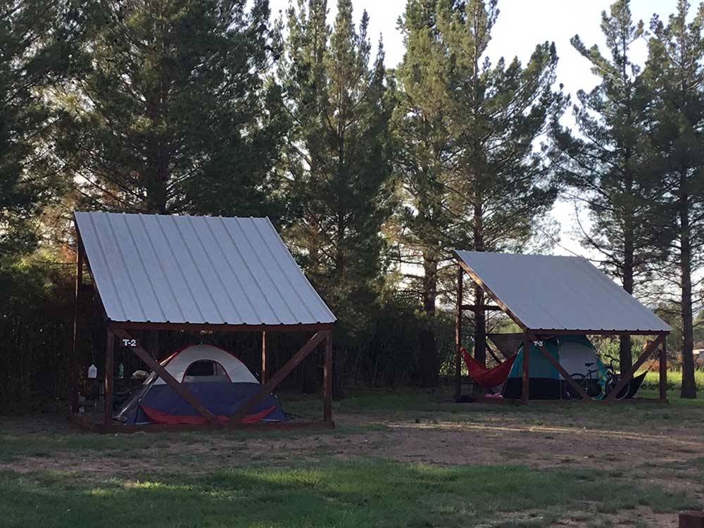 Covered tent spots among large grassy lawn area at LOST ALASKAN RV PARK