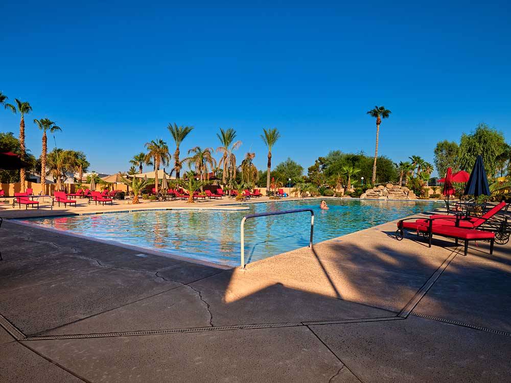 The large swimming pool with red lounge chairs at PUEBLO EL MIRAGE RV & GOLF RESORT