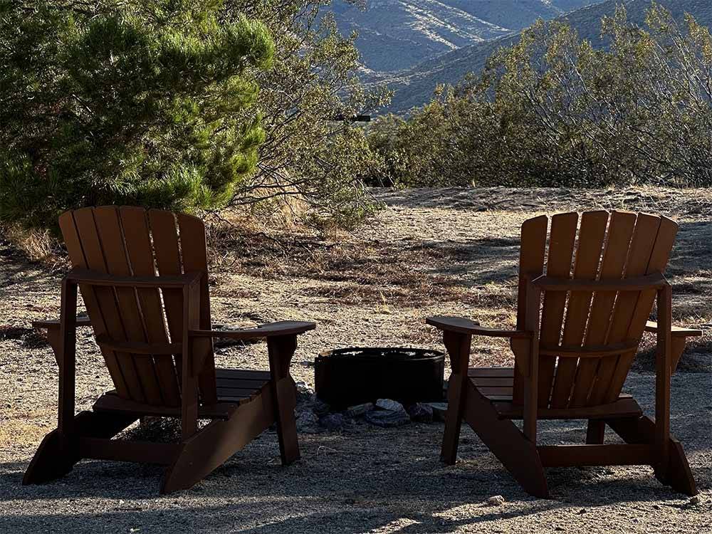 Two chairs next to a fire pit at STAGECOACH TRAILS RV PARK