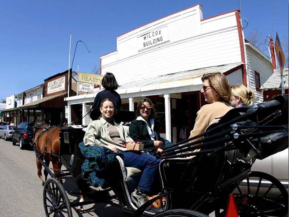 Four ladies riding in a carriage thru the town nearby at STAGECOACH TRAILS RV PARK